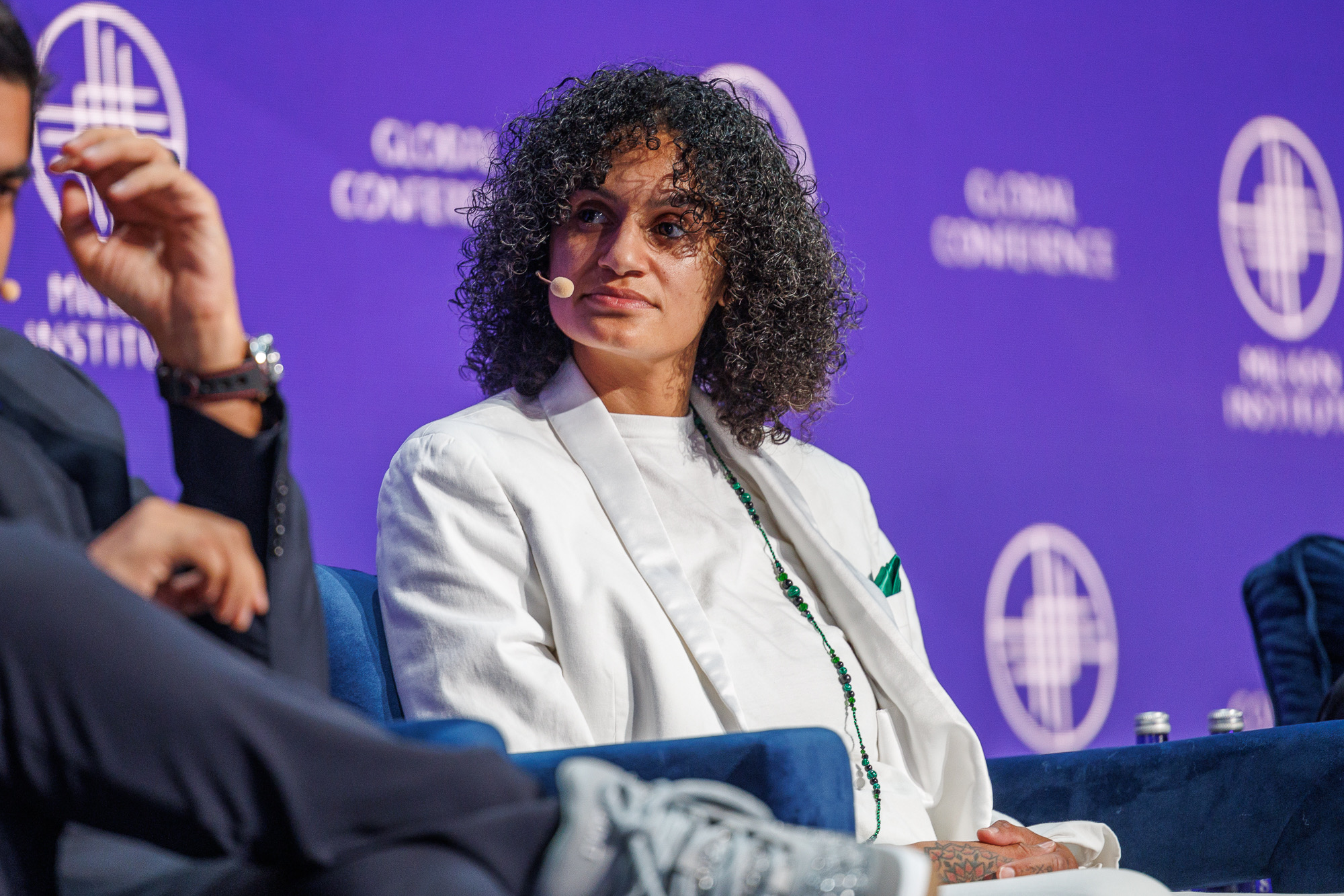 X. Eyee speaking on a panel at the Milken Global Conference
